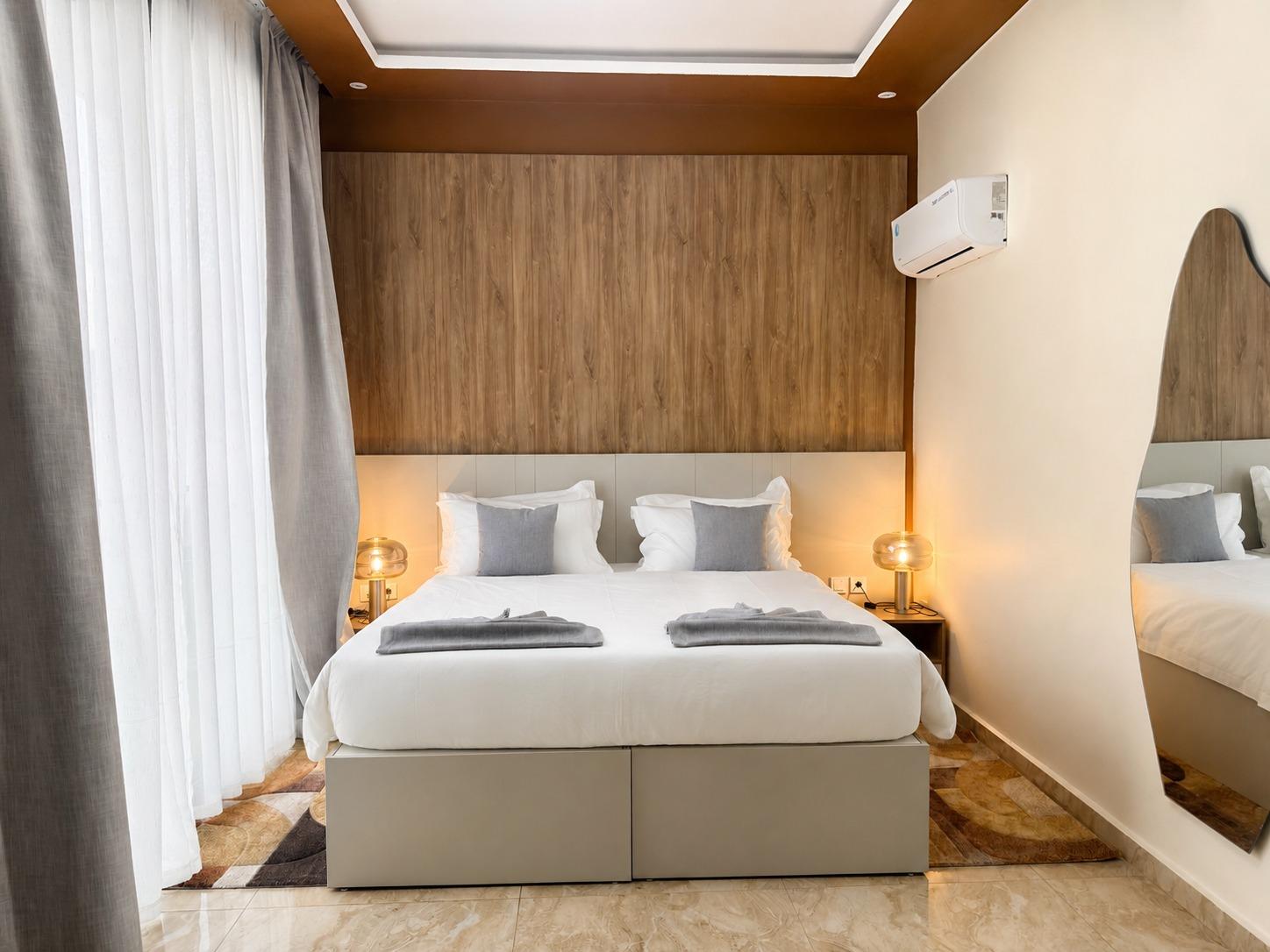 Suite Azur — une chambre claire, lampes de chevet allumées