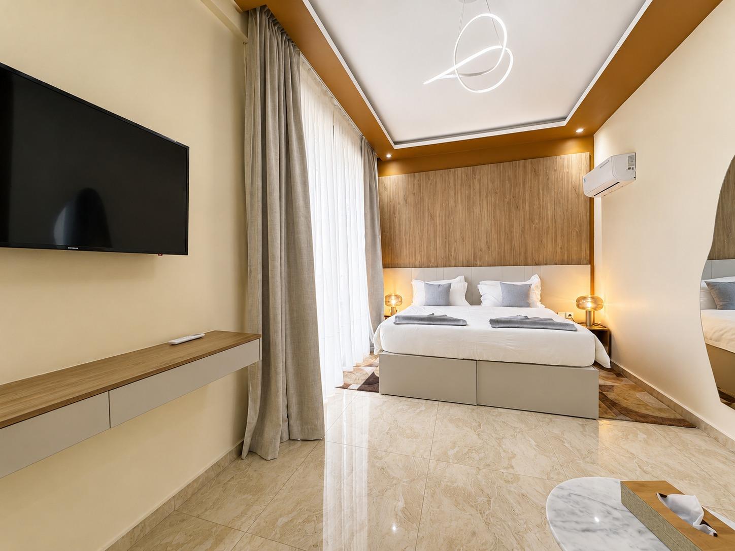 Suite Azur — une chambre, écran mural et rideaux tirés