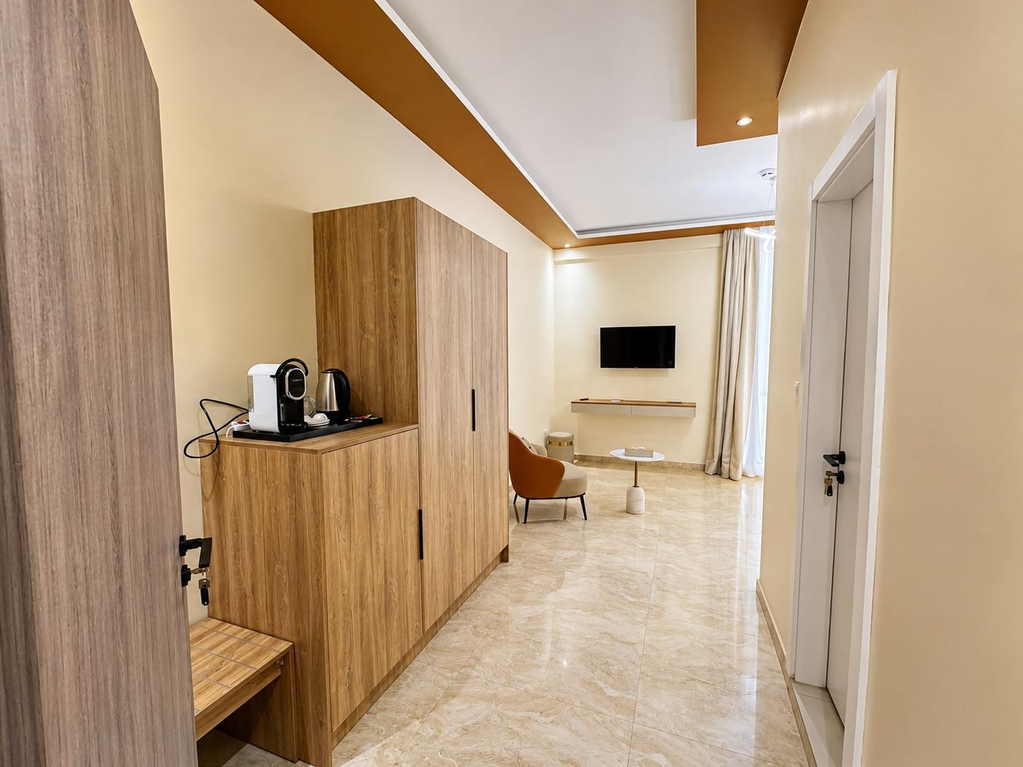 Suite Azur — la desserte et son plateau : machine à café et bouilloire, la chambre au fond
