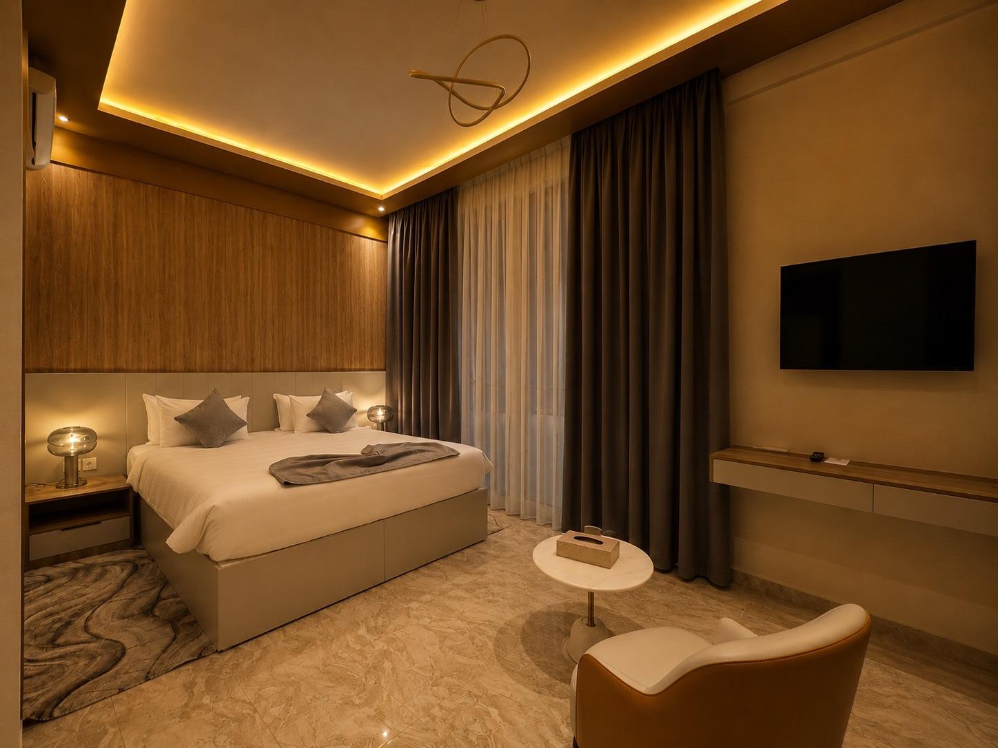 Suite Lagune — la chambre en soirée, lampes allumées et écran mural