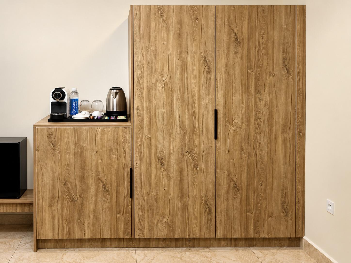 Chambre Standard — l'armoire et la desserte, avec la machine à café, la bouilloire et les capsules