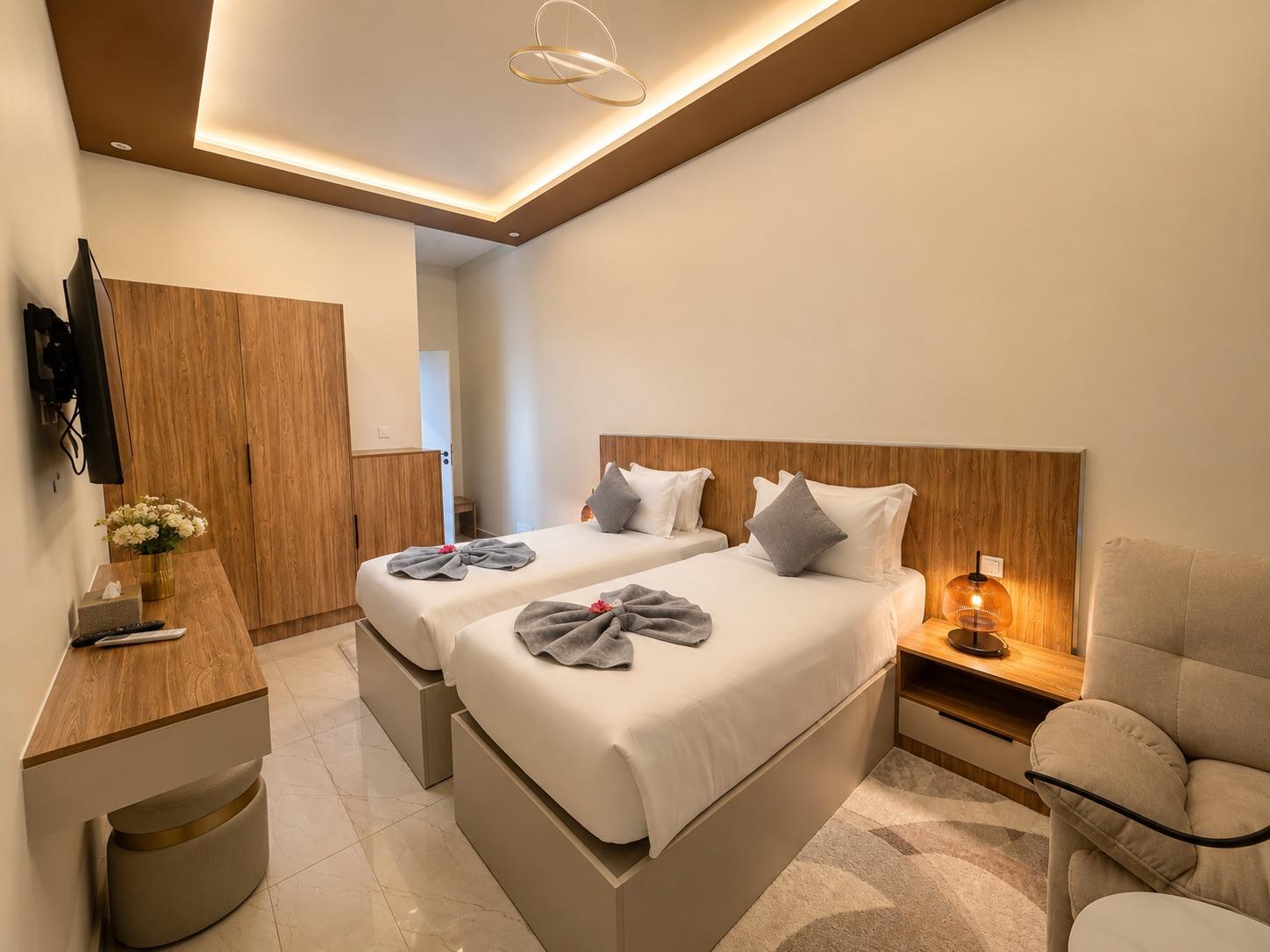 Suite SO'MOON — une chambre, tête de lit en bois, fauteuil et écran mural