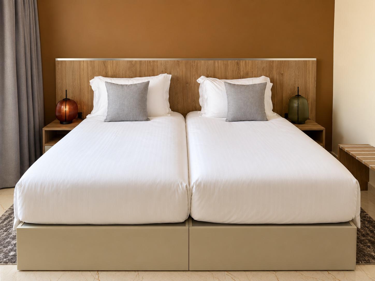 Chambre Twin — les deux lits vus de face, lampes allumées