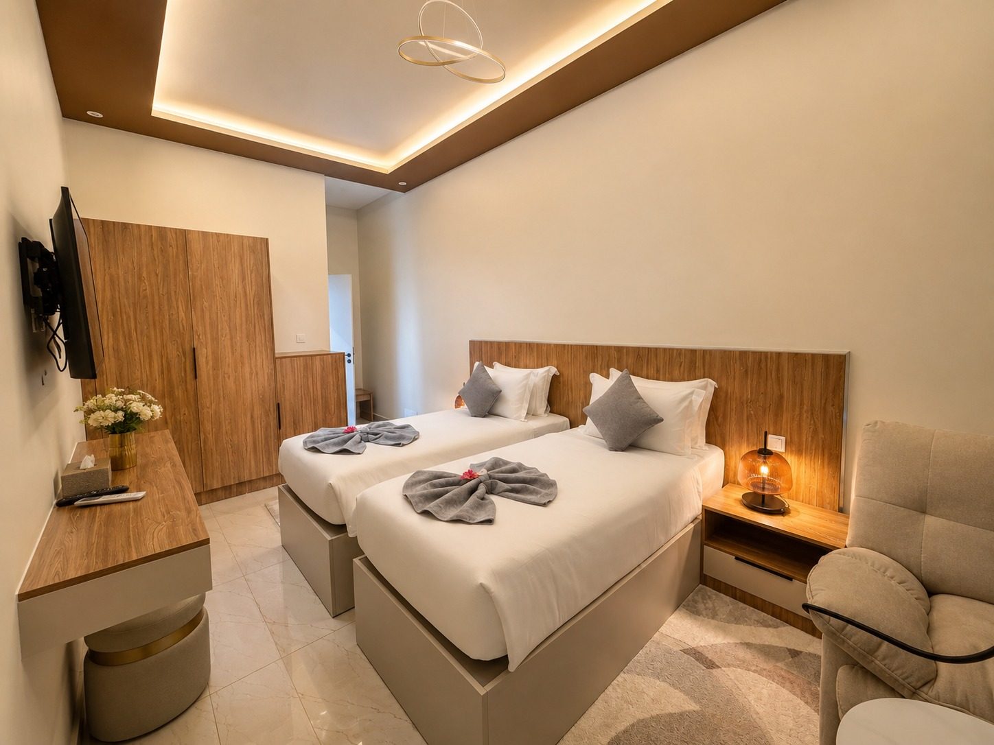 Suite SO'MOON — une chambre, tête de lit en bois, fauteuil et écran mural