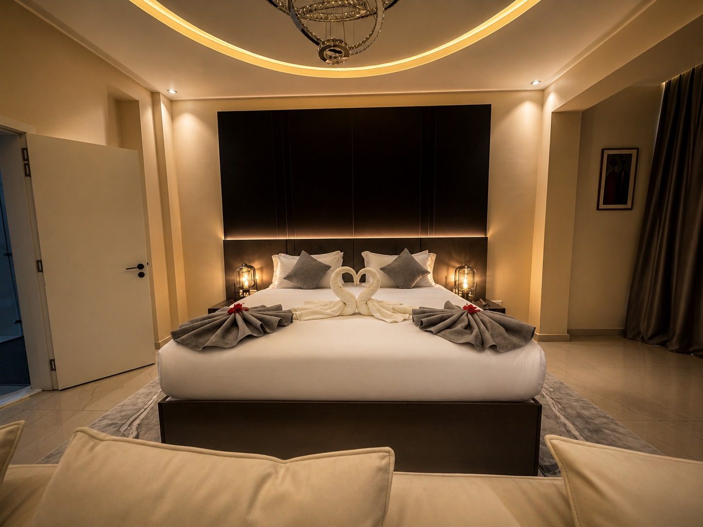 Suite SO'MOON — la chambre parentale : lit large, tête de lit sombre et rideaux tirés