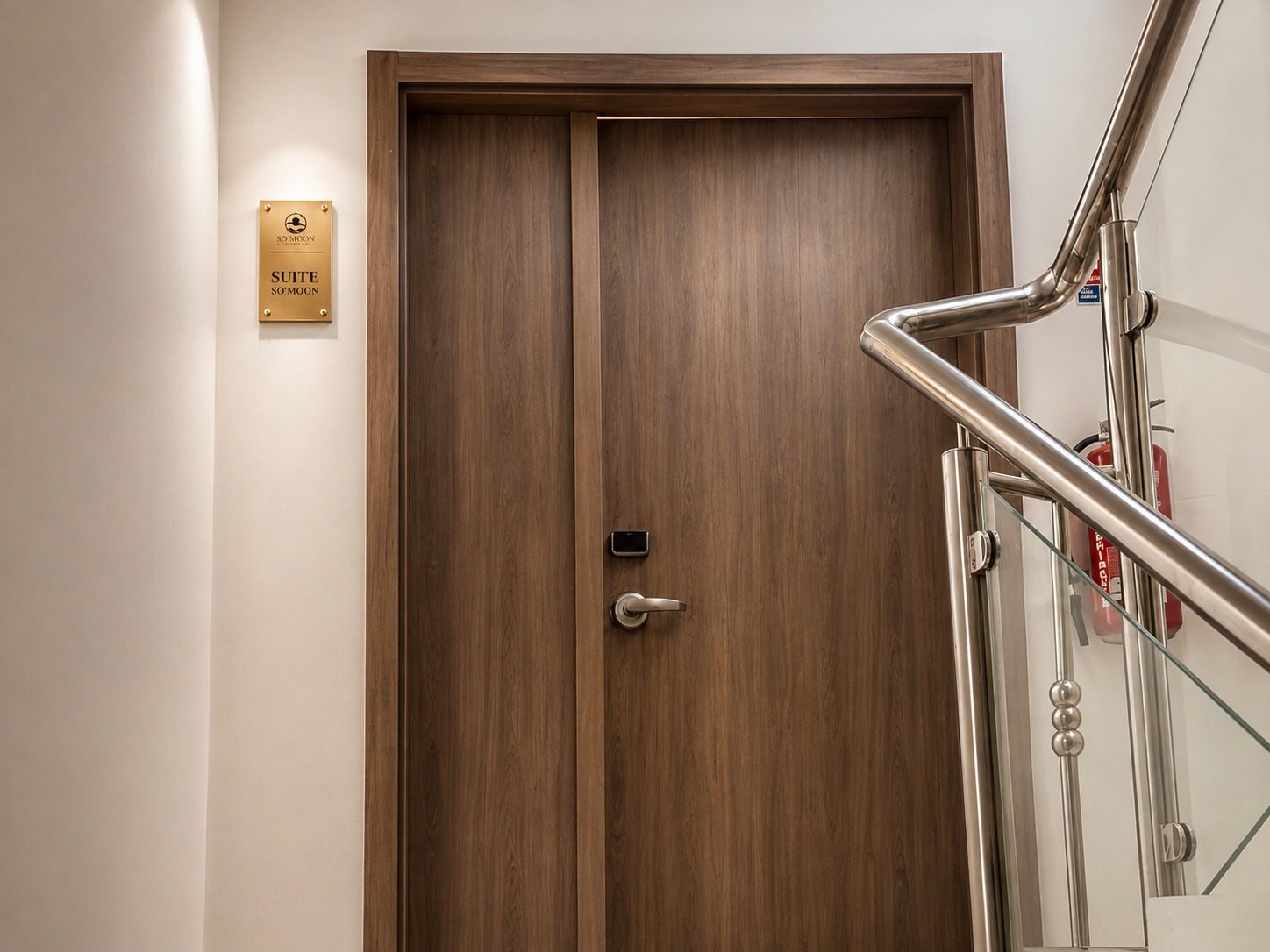 Suite SO'MOON — la porte d'entrée en bois et la rampe du palier