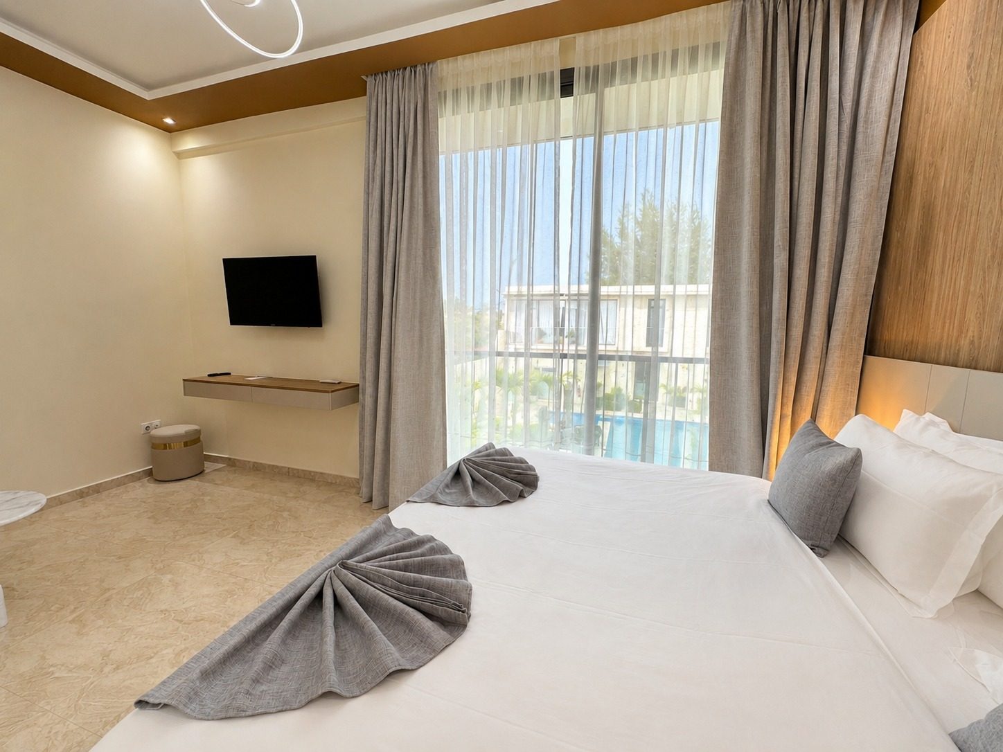 Suite Azur — la chambre ouverte sur la cour et la piscine, en plein jour