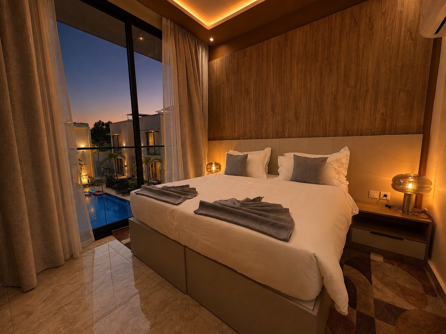 La même chambre de la Suite Azur à l'heure bleue, la cour et la piscine éclairées