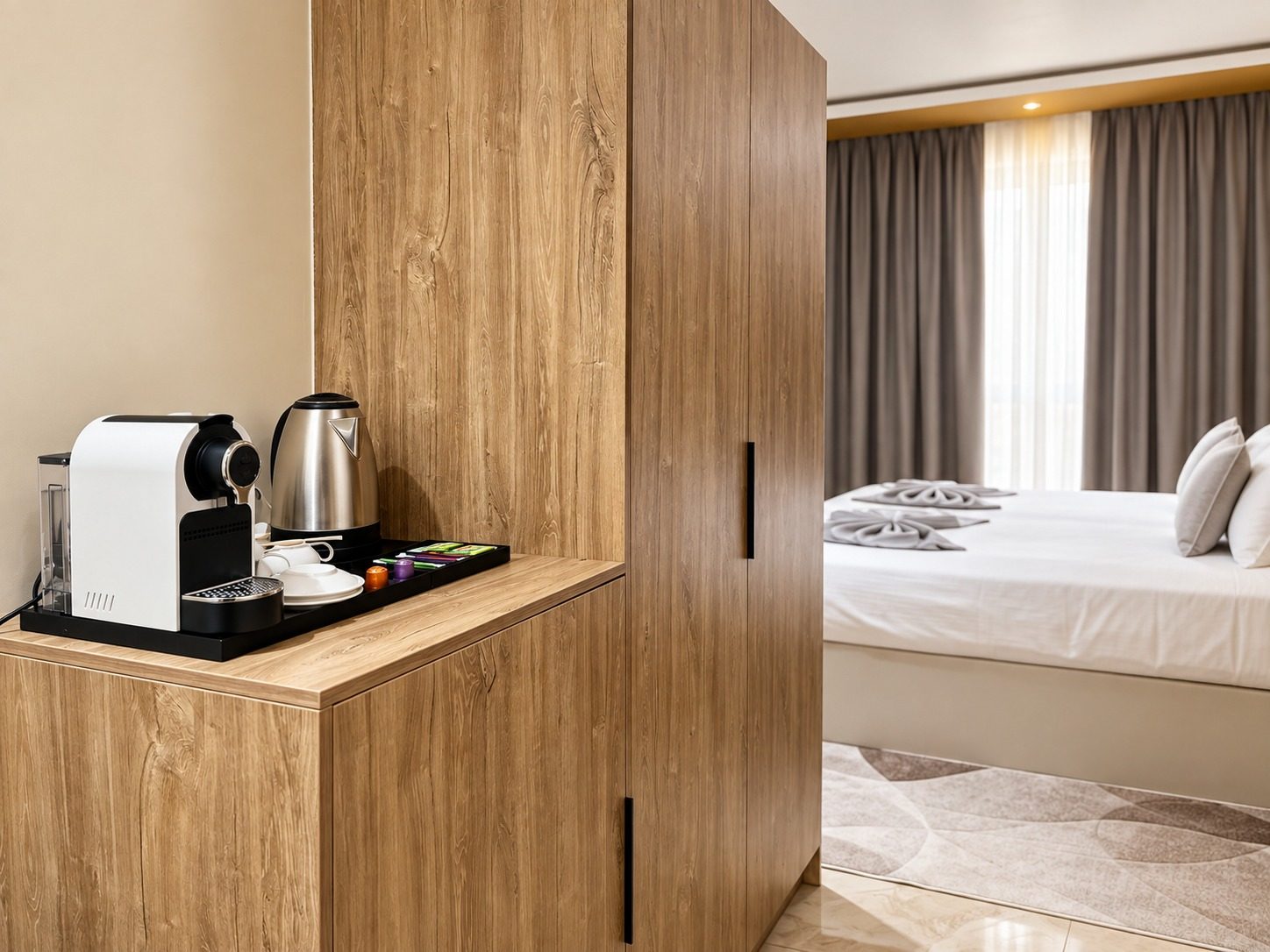 Suite Azur — la machine à café et la bouilloire sur la desserte, l'armoire et le lit en enfilade