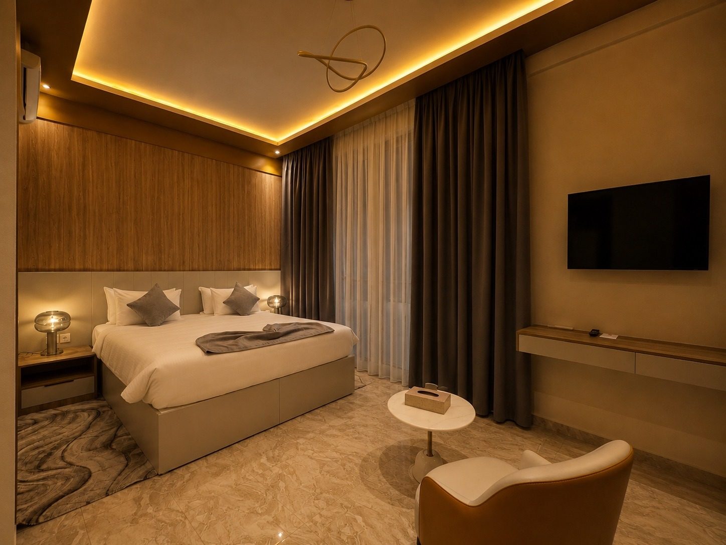 Suite Lagune — la chambre en soirée, lampes allumées et écran mural